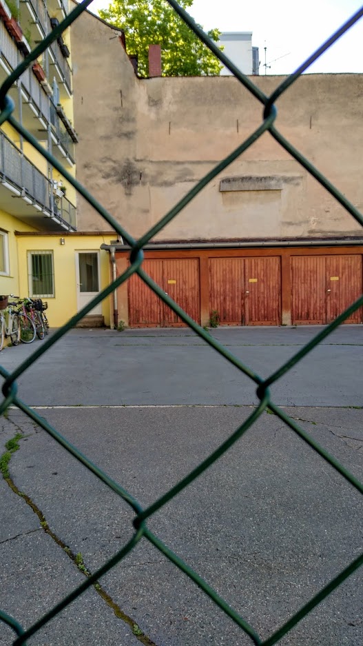Blick auf einen privaten Innenhof, in unmittelbarer Nähe der Hesperidengärten. Schon bricht das Grün durch den Asphalt.