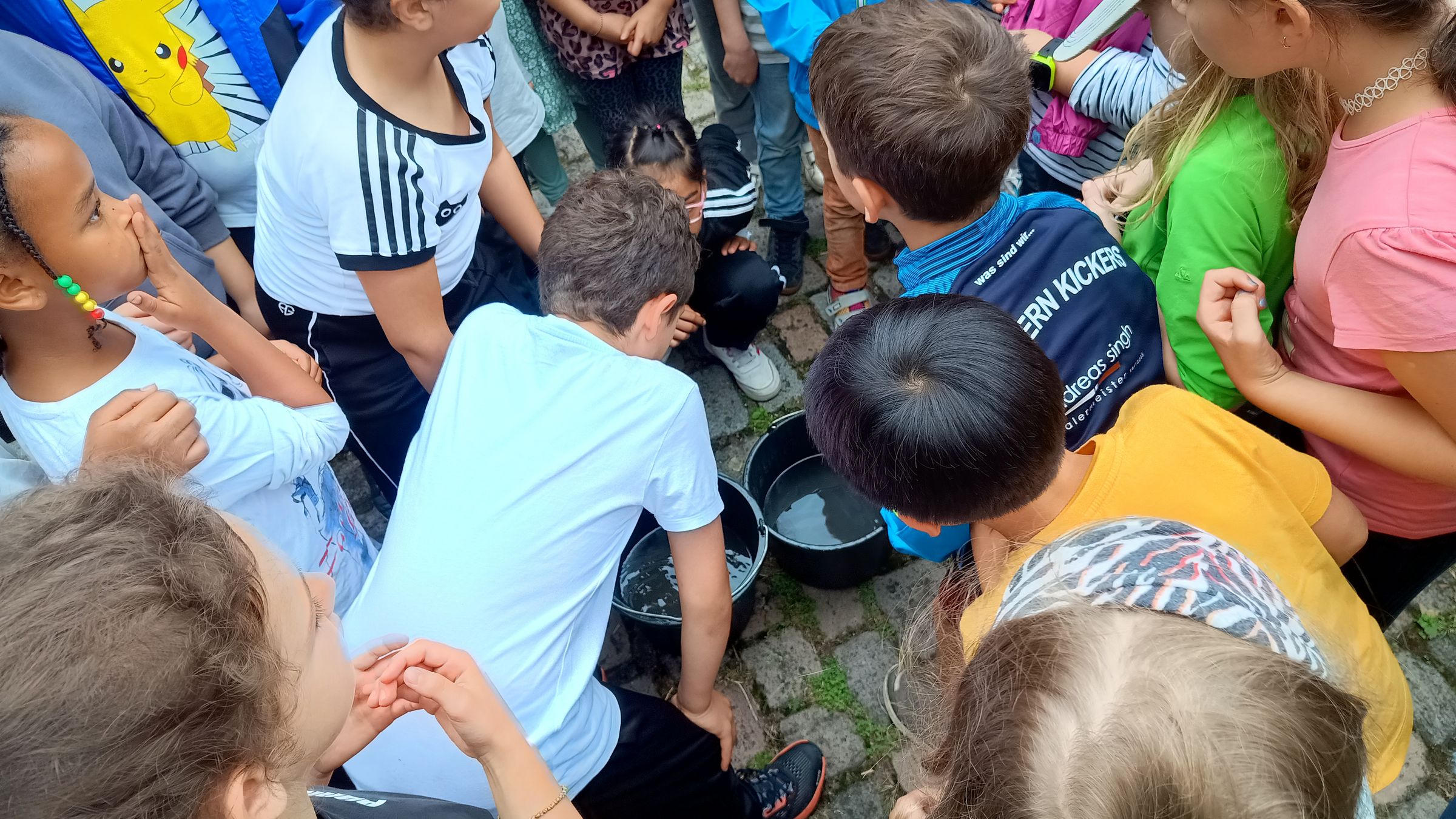 Kinder um Wassereimer